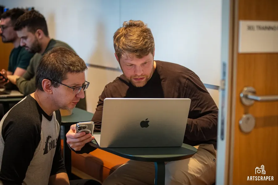 Two workshop participants working through an exercise on one laptop